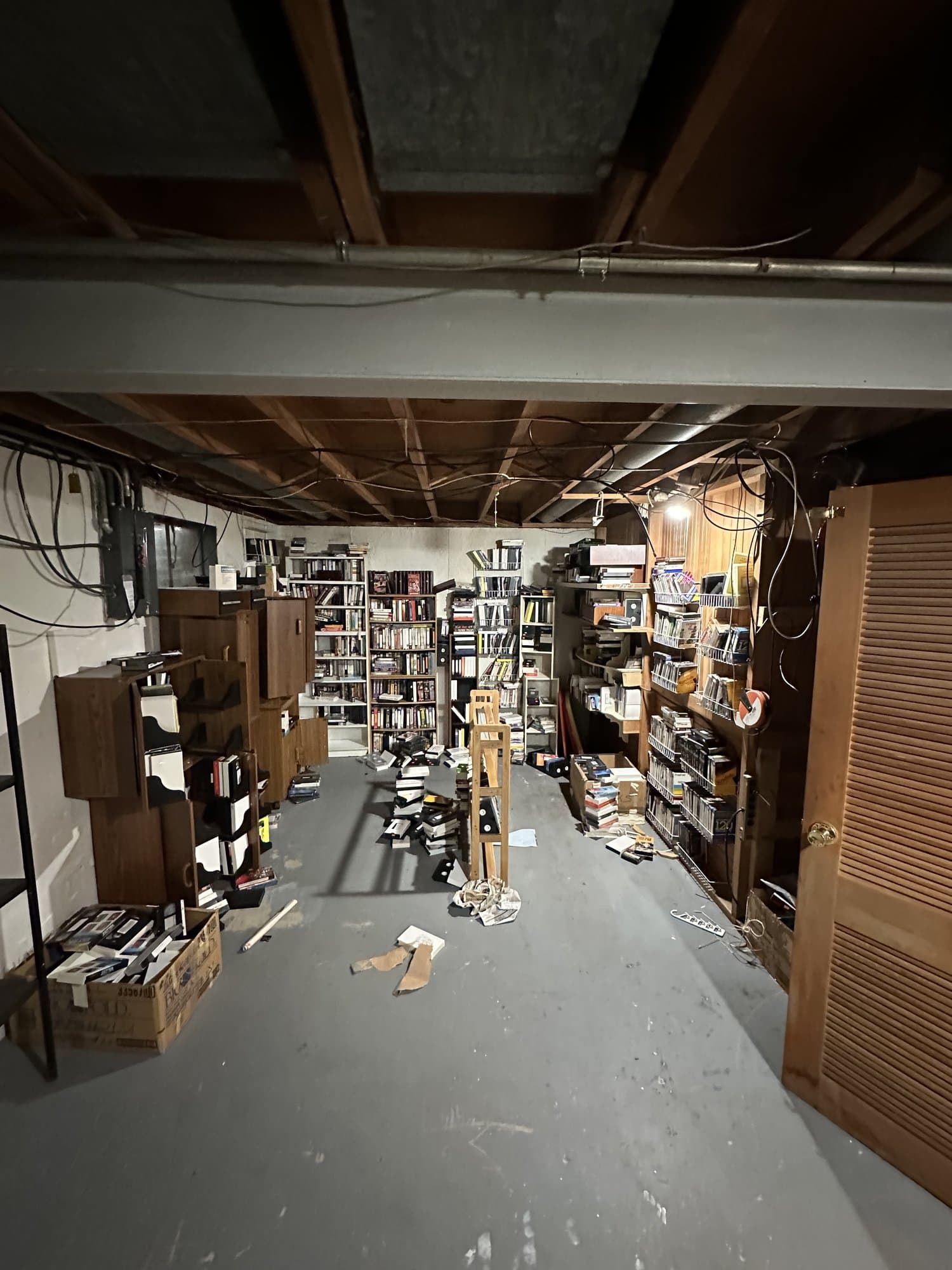 Basement full of bookshelves, boxes, and household clutter