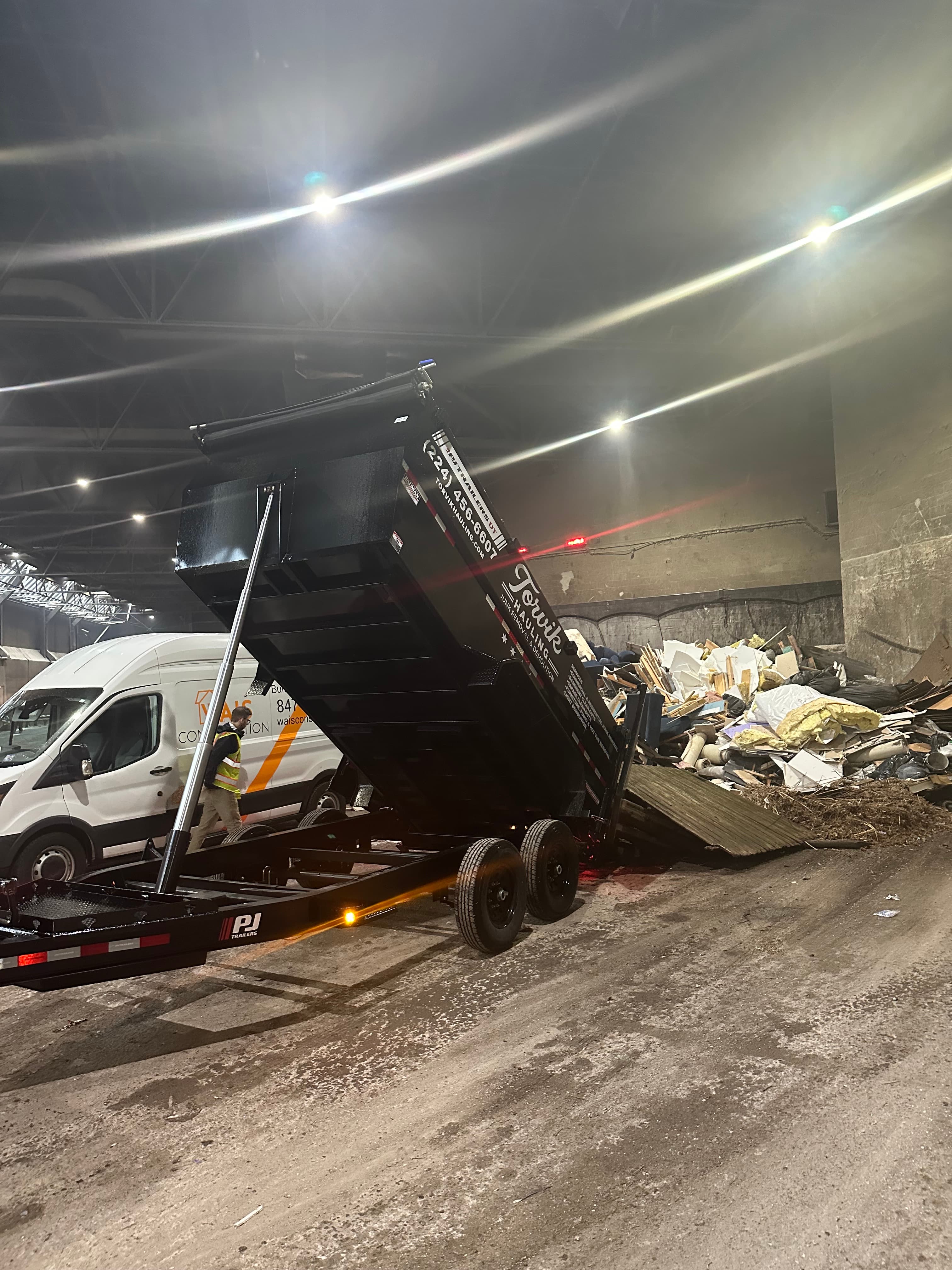 Torvik Hauling dump trailer unloading construction and household debris at a licensed waste transfer station
